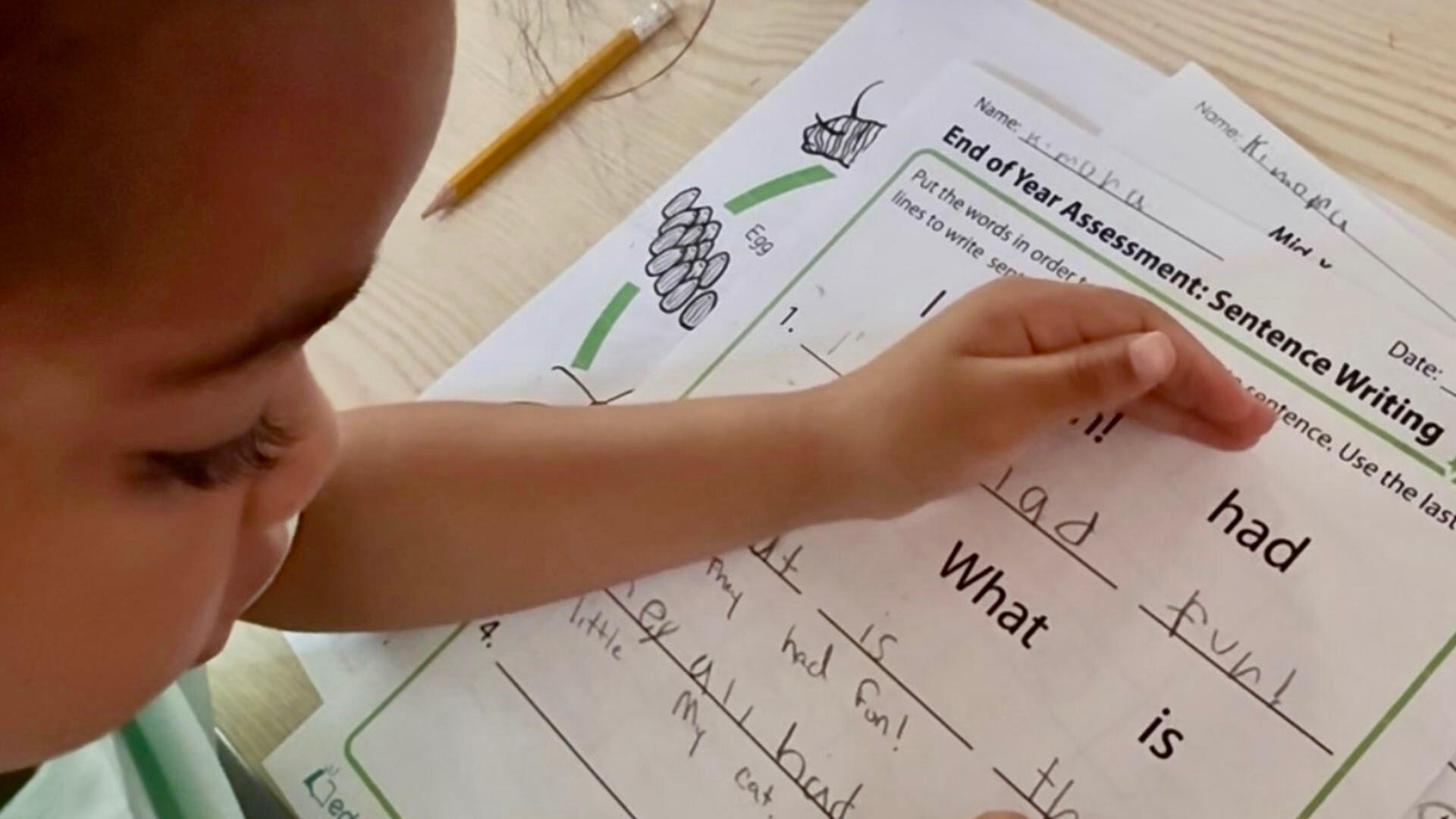 Early Learning & Kindergarten Readiness Young child practicing reading and sentence writing during a structured learning activity at Advanced Childcare Services LLC